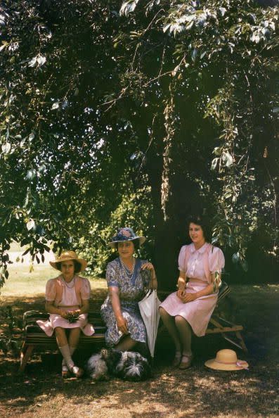<p>Queen Elizabeth takes shade from the sun beneath a tree, with her daughters Princesses Elizabeth and Margaret in the grounds of Windsor Castle.</p>