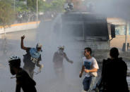 Demonstrators react in front of a vehicle during clashes with security forces following a rally against the government of Venezuela's President Nicolas Maduro and to commemorate May Day in Caracas, Venezuela May 1, 2019. REUTERS/Manaure Quintero