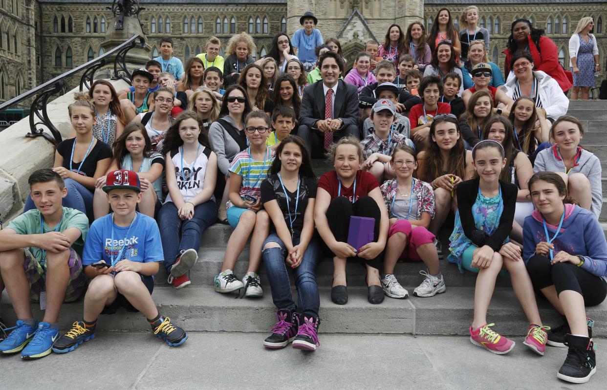 Justin Trudeau poses with school children in Ottawa June 11, 2014. REUTERS/Chris Wattie 