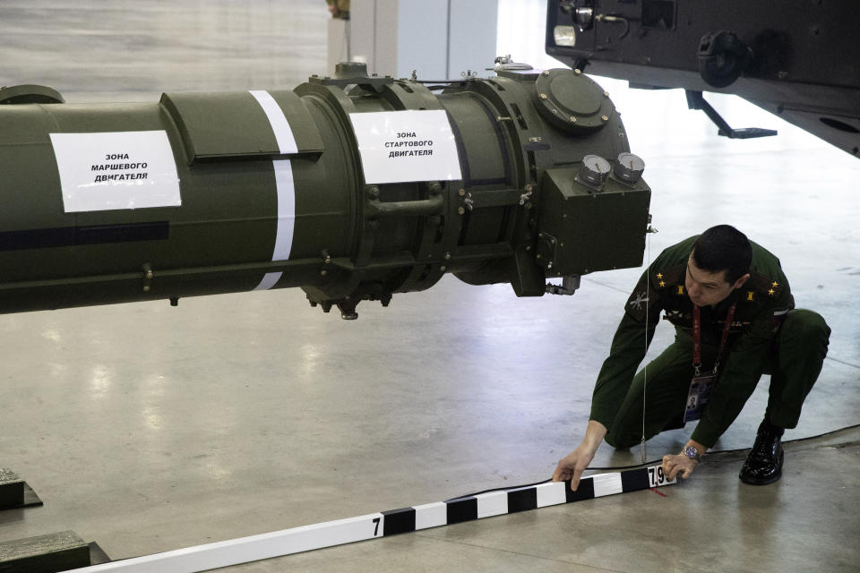 A Russian military officer measures the 9M729 land-based cruise missile on display in Kubinka outside Moscow, Russia, Wednesday, Jan. 23, 2019. The Russian military on Wednesday rolled out its new missile and spelled out its specifications, seeking to dispel the U.S. claim that the weapon violates a key nuclear arms pact. (AP Photo/Pavel Golovkin)