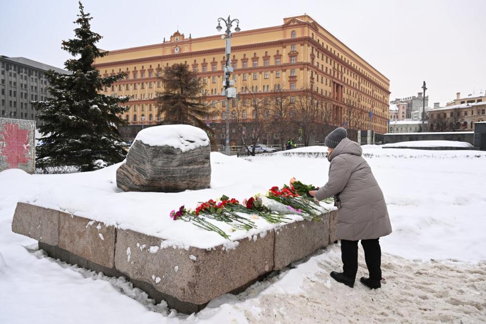 A woman lays flowers for Navalny at the Solovetsky Stone, a monument to political repression and one of the locations where tributes have been left by Russians for the late opposition leader (AFP via Getty)