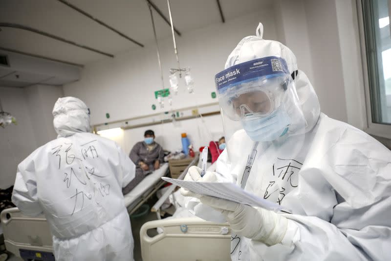 Medical worker in protective suit checks a patient's records at Jinyintan hospital in Wuhan, the epicentre of the novel coronavirus outbreak