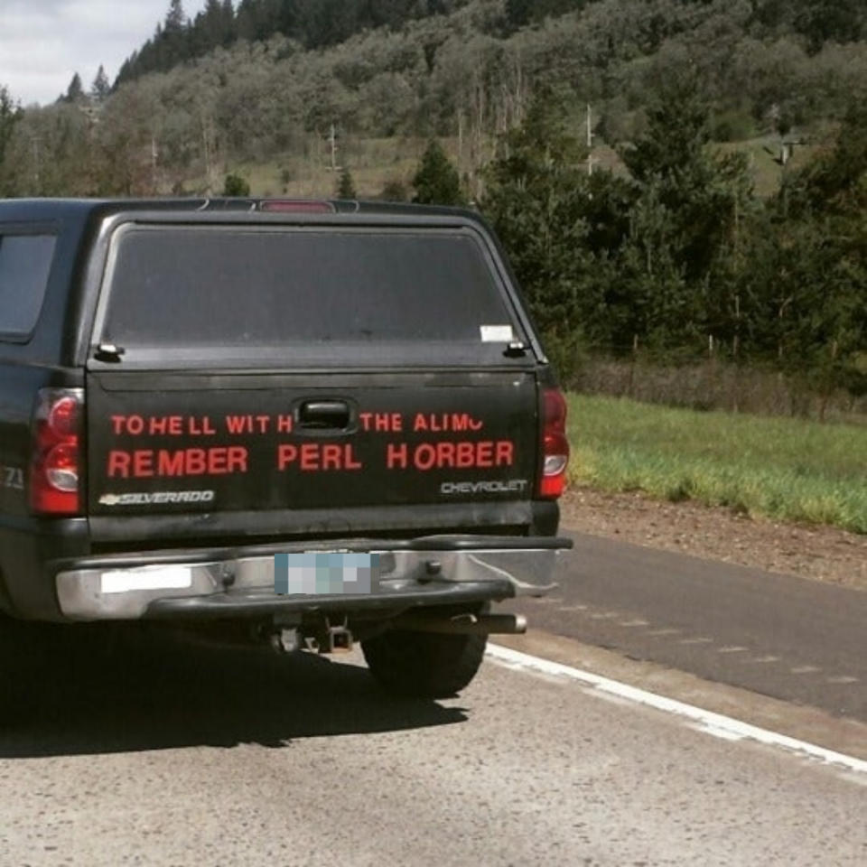 Back of a truck with a misspelled text sticker "REMBER PERL HORBOR" on the window