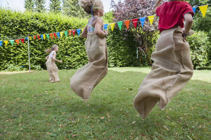 Kids have a sack race at a birthday party.