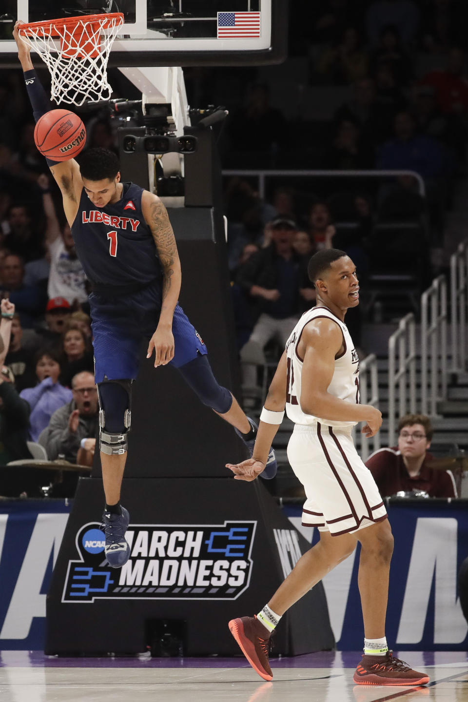 Liberty guard Caleb Homesley, left, dunks over Mississippi State guard Robert Woodard during the second half of a first-round game in the NCAA men's college basketball tournament Friday, March 22, 2019, in San Jose, Calif. (AP Photo/Jeff Chiu)