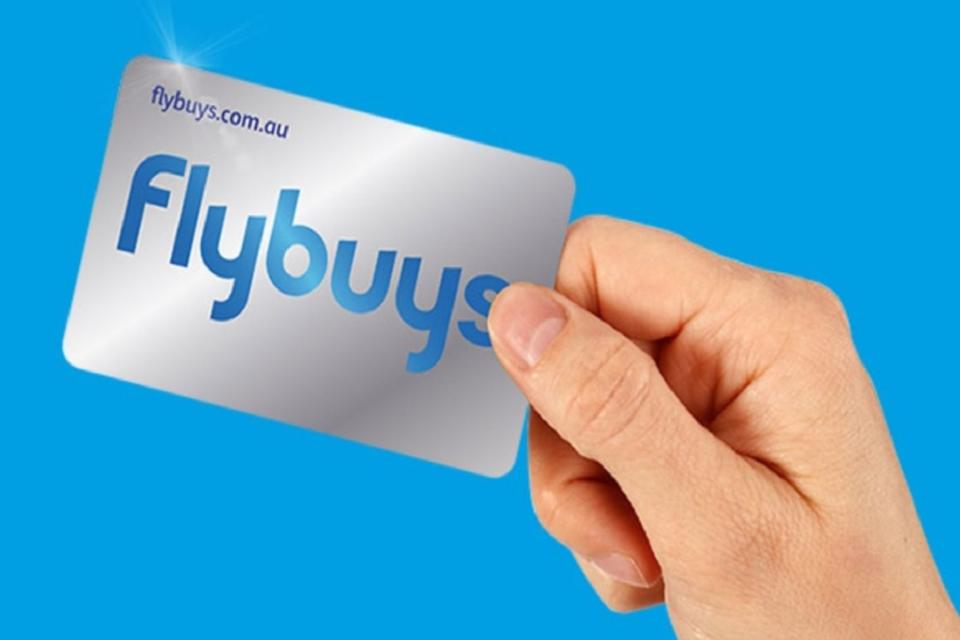 Man's hand holding Flybuys card