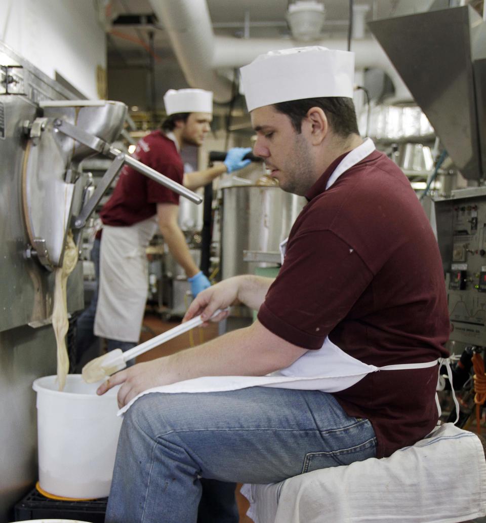 In this photo taken Thursday, July 11, 2013, Aaron Fournier, right, makes a fresh batch of Indian Pudding ice cream and Austin Sorette works on chocolates at the Granite State Candy Shoppe in Concord, N.H. A gaggle of eateries, an independent movie theater, several charming (and killer good) bakeries and a kick-butt independent bookstore has turned Concord into a must-stop for folks headed north for the lakes and mountains. (AP Photo/Jim Cole)