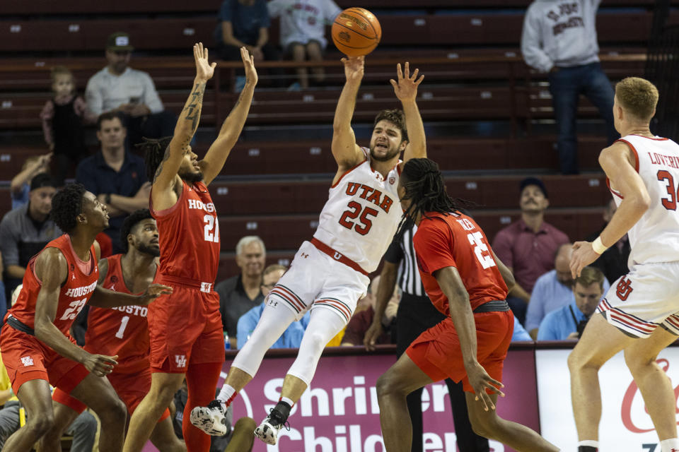 Utah's Rollie Worster (25) passes the ball against the defense of Houston's Emanuel Sharp (21) and Joseph Tugler (25) in the first half of an NCAA college basketball game during the Charleston Classic in Charleston, S.C., Friday, Nov. 17, 2023. (AP Photo/Mic Smith).