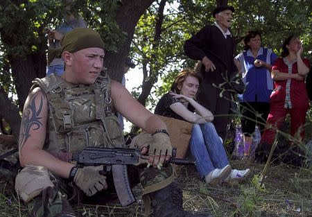 Ukrainian army soldier from battalion "Aydar" guards local residents as they leave the village of Metalist near the eastern Ukrainian city of Luhansk July 11, 2014. REUTERS/Viktor Gurniak