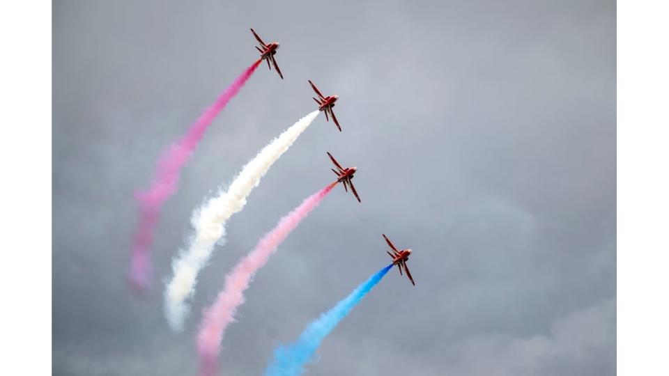 Four aircraft in the Red Arrows flying on a cloudy day