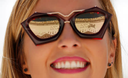 The logo of the 74th Venice Film Festival is seen reflected in the sunglasses of a woman in Venice, Italy August 29, 2017. REUTERS/Alessandro Bianchi