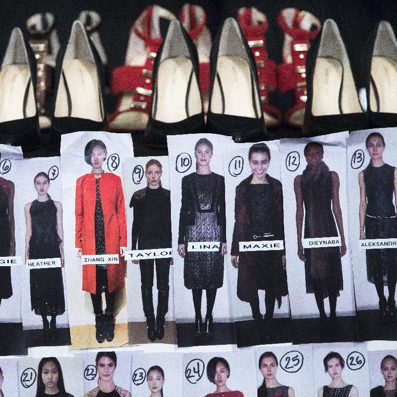 Shoes rest on a table beside a look board backstage before the Carmen Marc Valvo Fall 2014 collection is modeled during Fashion Week, Friday, Feb. 7, 2014, in New York. (AP Photo/John Minchillo)