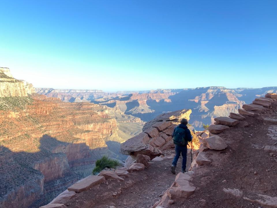 A man hiking along the edge of the Grand Canyon