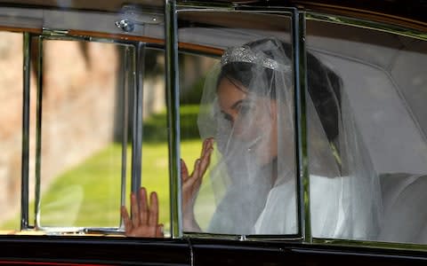 Meghan waves to photographers as she leaves her hotel - Credit: DARREN STAPLES /Reuters