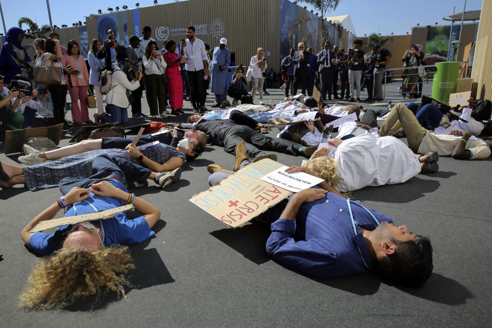 Medical workers from various countries perform a "die-in" to protest the effect of climate change on health issues at the COP27 U.N. Climate Summit, Friday, Nov. 11, 2022, in Sharm el-Sheikh, Egypt. (AP Photo/Thomas Hartwell)