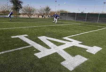 Los Angeles Dodgers players warm up on a side field as they prepare for their bullpen session during MLB Cactus League spring training at the team's facility in Glendale, Arizona in this February 14, 2013 file photo. REUTERS/Ralph D. Freso/Files