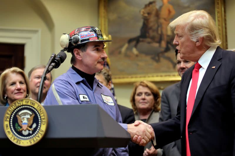 FILE PHOTO: FILE PHOTO: Michael Nelson, a coal miner worker shakes hands with U.S. President Donald Trump as he prepares to sign Resolution 38, at the White House in Washington, U.S.