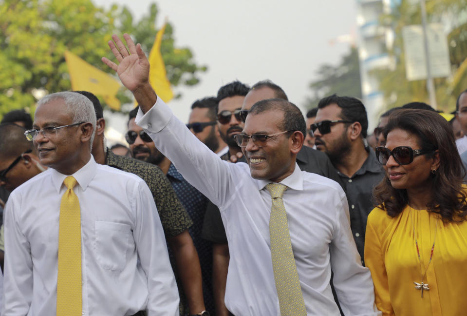 Maldives’ former president Mohamed Nasheed, center, waves to the public in Male, Maldives, Thursday, Nov.1, 2018. Nasheed, the first democratically elected president of the Maldives returned home Thursday after more than two years in exile to escape a long prison term. President elect Ibrahim Mohamed Solih is on his right. (AP Photo/Mohamed Sharuhaan)