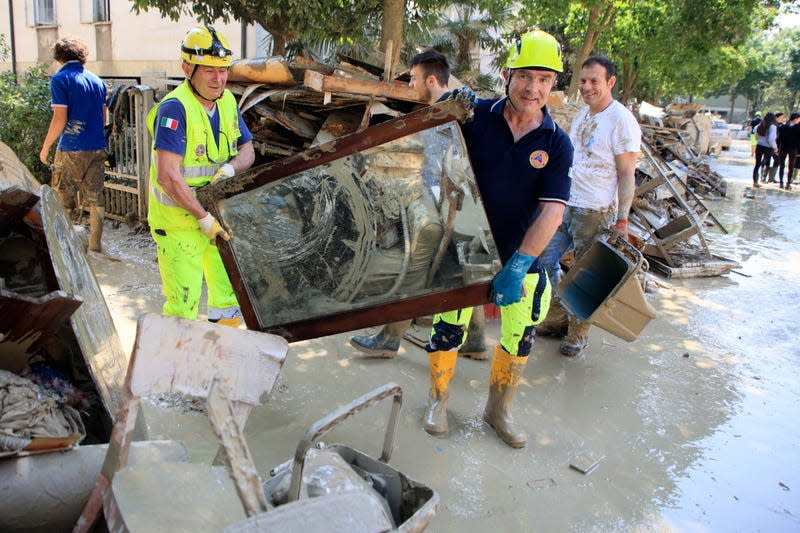 Photo of two people carrying mud covered mirror