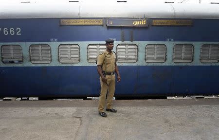 A policeman stands guard next to a passenger train in which two explosions occurred, at the railway station in Chennai May 1, 2014. REUTERS/Babu