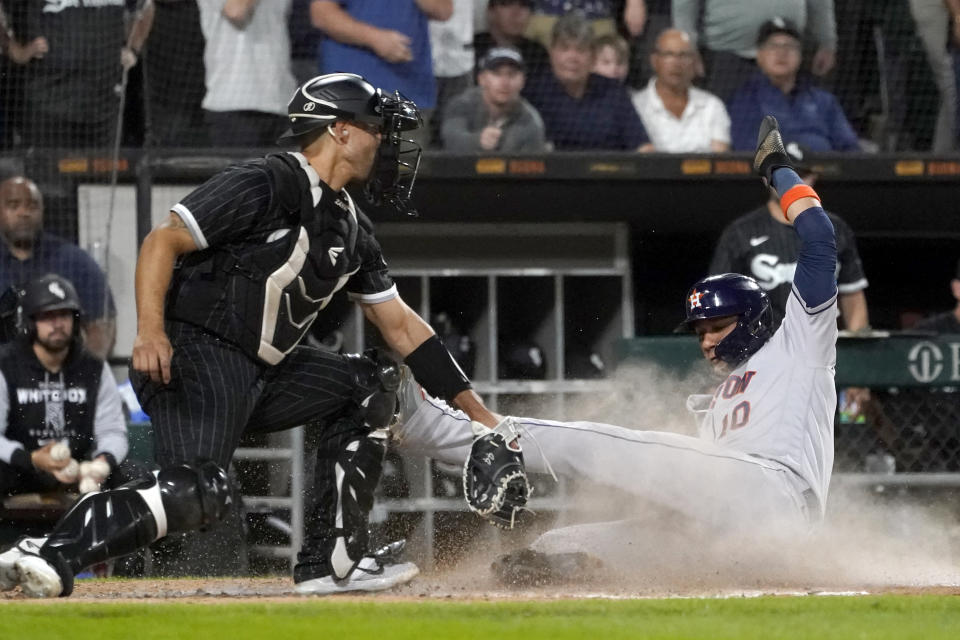 Houston Astros' Yuli Gurriel (10) scores next to Chicago White Sox catcher Seby Zavala during the third inning of a baseball game Tuesday, Aug. 16, 2022, in Chicago. (AP Photo/Charles Rex Arbogast)