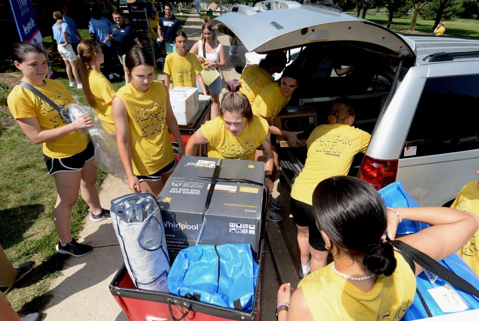 University of Illinois Springfield volunteers help students moving into Lincoln Hall unpack their vehicles Tuesday.