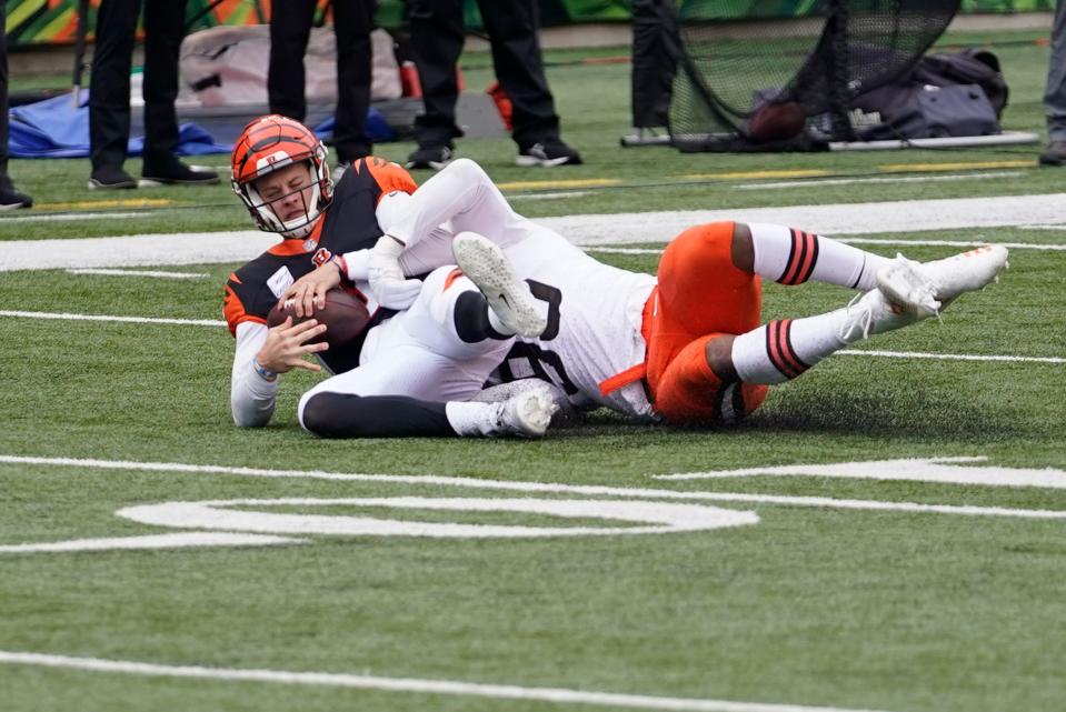 Cincinnati Bengals quarterback Joe Burrow, left, is sacked by Cleveland Browns' Myles Garrett (95) during the first half of an NFL football game, Sunday, Oct. 25, 2020, in Cincinnati. (AP Photo/Bryan Woolston)