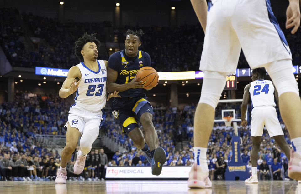 Marquette's Oso Ighodaro, right, drives against Creighton's Trey Alexander during the first half of an NCAA college basketball game on Tuesday, Feb. 21, 2023, in Omaha, Neb. (AP Photo/Rebecca S. Gratz)