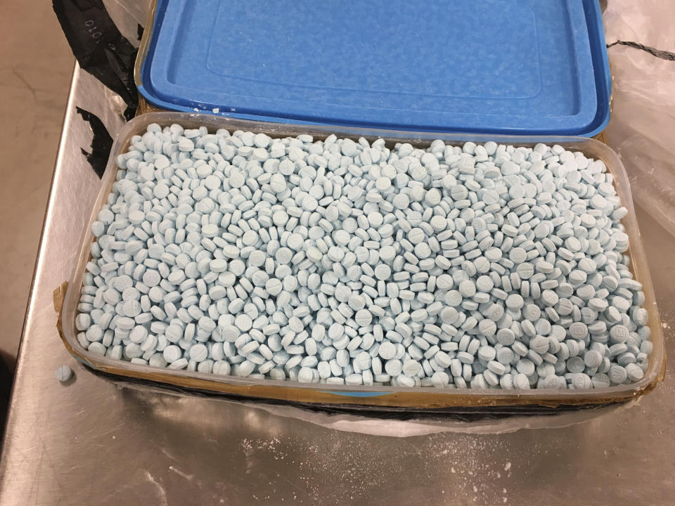 This photo provided by the U.S. Drug Enforcement Administration's Phoenix Division shows some of the 30,000 fentanyl pills the agency seized in one of its bigger busts, in Tempe, Ariz., in August, 2017. The picture shows just one of four plastic containers that were stuffed with the tablets. The Southwest, and Arizona in particular, has become Ground Zero in the nation's fentanyl crisis with plenty of pills and powder staying behind after the drug is repackaged and sent on to New York and other U.S. destinations. Stamped with "M" and "30" like the pain medication oxycodone, the fentanyl-laced pills showed up in recent years as the Sinaloa cartel's newest product. (Drug Enforcement Administration via AP)