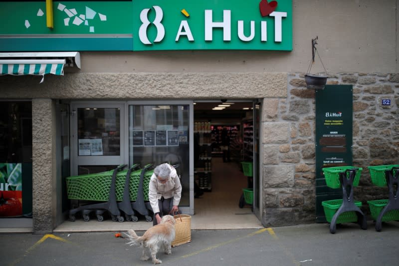 A woman leaves a minimarket in Saint-Jacut-de-la-Mer in Brittany