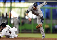 Colorado Rockies shortstop Troy Tulowitzki, right, watches his throw to first base after forcing out Miami Marlins' Casey McGehee (9) out at second base during the first inning of a baseball game, Thursday, April 3, 2014, in Miami. The Marlins' Garrett Jones was out a first for a double play. (AP Photo/Lynne Sladky)