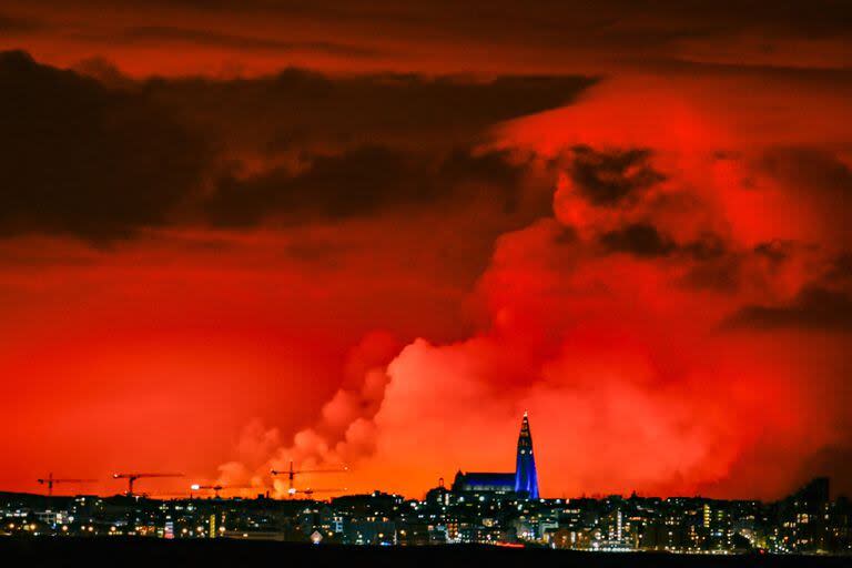 El horizonte de Reykjavik tiene como telón de fondo un cielo de color naranja debido a la lava fundida que fluye desde la fisura