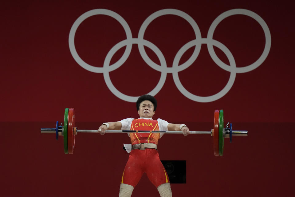 Hou Zhihui of China competes in the women's 49kg weightlifting event, at the 2020 Summer Olympics, Saturday, July 24, 2021, in Tokyo, Japan. (AP Photo/Luca Bruno)