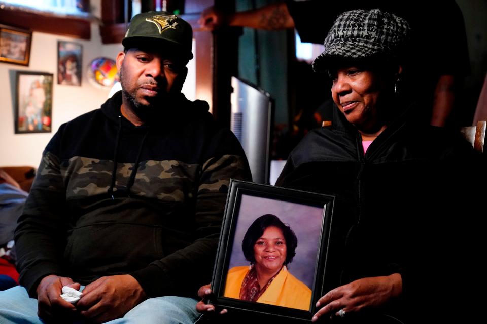 Wayne Jones, left, looks on as his aunt JoAnn Daniels, holds a photograph of his mother Celestine Chaney, who was killed in Saturday's shooting at a supermarket, during an interview with The Associated Press in Buffalo, N.Y., Monday, May 16, 2022.