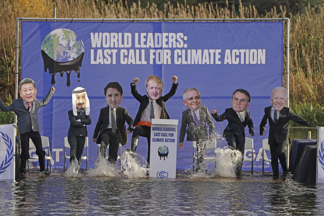 A replica of the COP26 summit's main UN negotiation stage, carrying activists dressed as world leaders, is half-sunk in the Clyde Canal during the COP26 summit in Glasgow, Scotland Tuesday Nov. 9, 2021. The U.N. climate summit in Glasgow has entered it's second week as leaders from around the world, are gathering in Scotland's biggest city, to lay out their vision for addressing the common challenge of global warming.(Andrew Milligan/PA via AP)