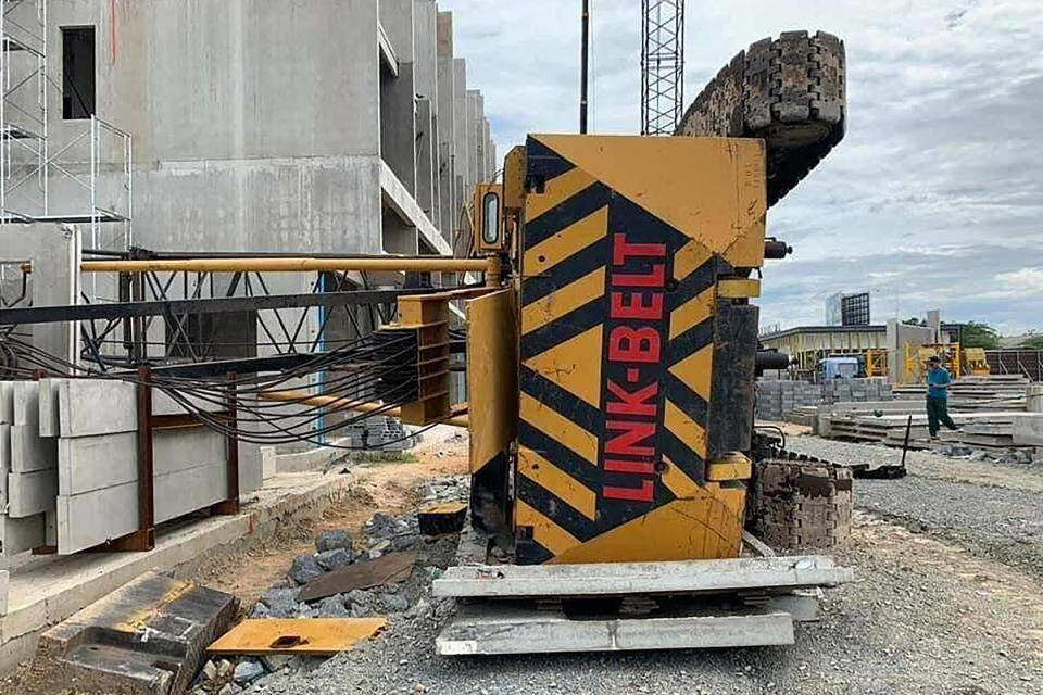 In this photo provided by the Poipet Authority Police, a crane lies near a Cambodia-Thai international border gate in Poipet, west of Phnom Penh, Cambodia, Wednesday, Aug. 12, 2020. The construction crane collapsed Wednesday, was being operated on ground made wet by rain, rendering it unstable, according to a police. (Poipet Authority Police via AP)