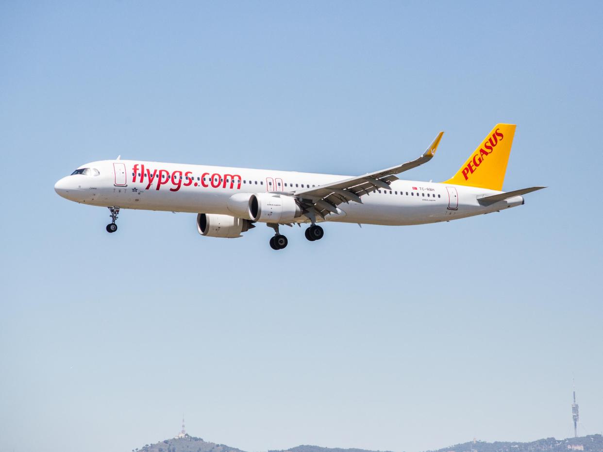 A Pegasus Airlines plane in the air, with a yellow tip