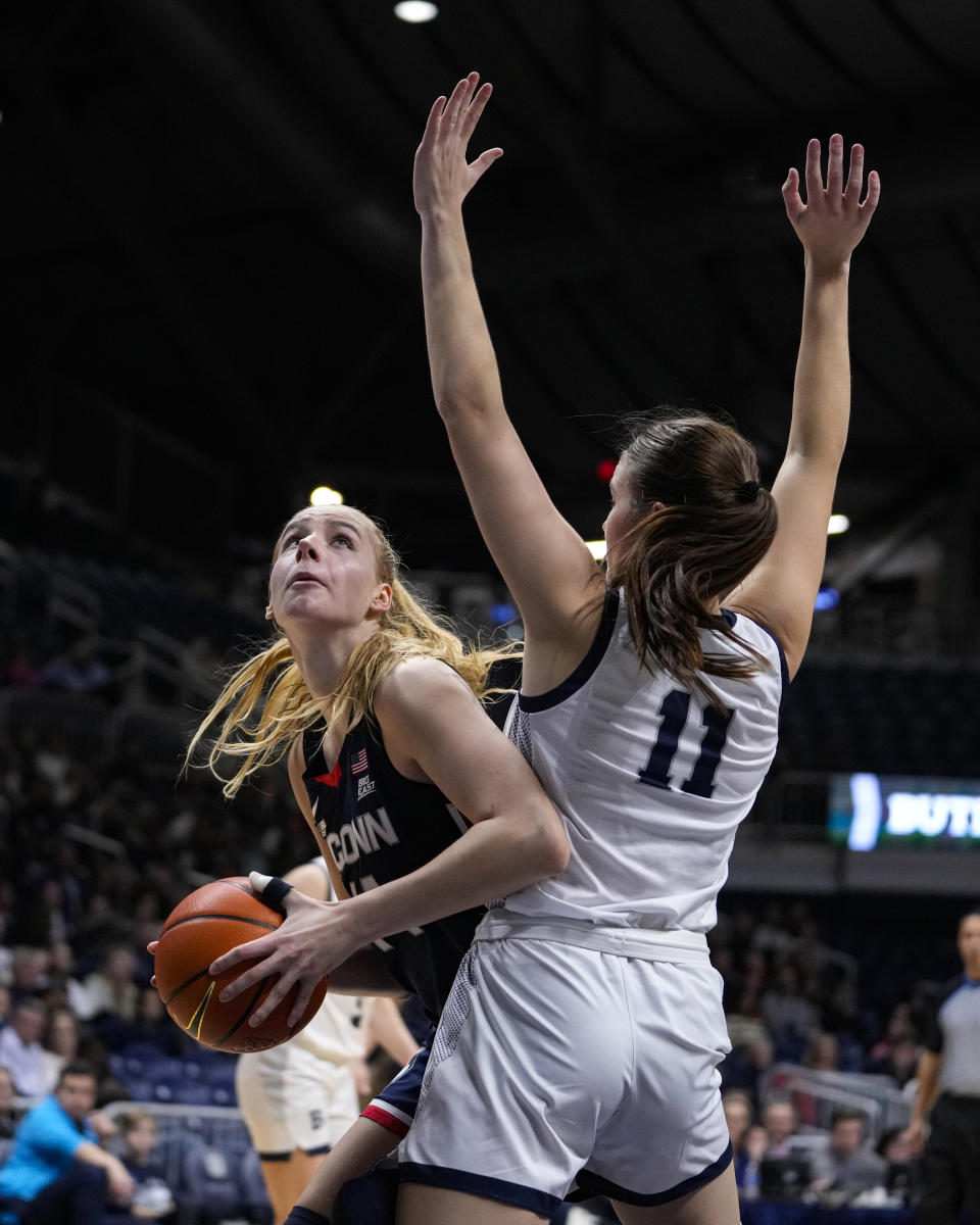 UConn forward Dorka Juhasz (14) shoots around dButler guard Tenley Dowell (11) during the second half of an NCAA college basketball game in Indianapolis, Tuesday, Jan. 3, 2023. (AP Photo/Michael Conroy)