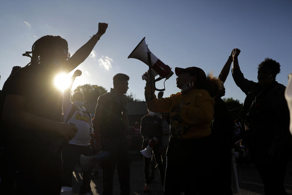 Protesters block a street outside the police station Wednesday, June 10, 2020, in Florissant, Mo. Demonstrators were calling attention to a video that appears to show a Florissant police detective, who has since been fired, striking a man with his police car during a recent pursuit. (AP Photo/Jeff Roberson)