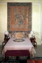 <p>La habitación de Wallis y Eduardo era una de las estancias más sencillas de la residencia, con un gran tapiz con el escudo de armas de la familia presidiendo la habitación y una cama con un escueto cabecero y dos mesillas de madera. </p>