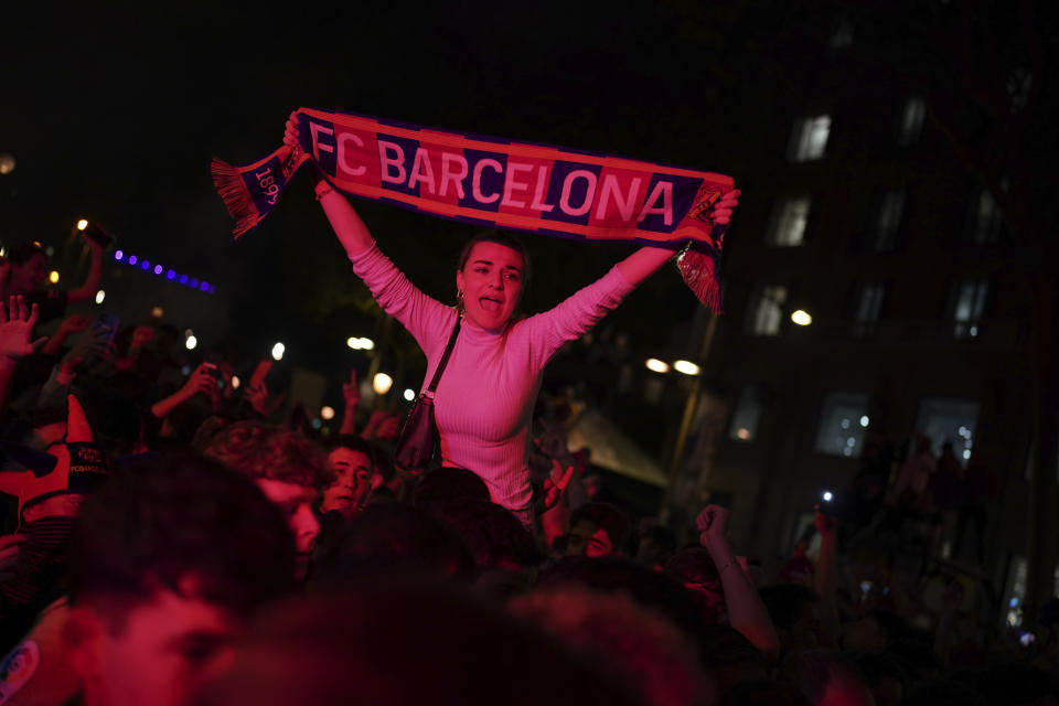 Barcelona fans celebrate in the street after their team won the Spanish La Liga championship by beating crosstown rivals Espanyol in Barcelona, Spain, Sunday May 14, 2023. (AP Photo/Joan Mateu Parra)