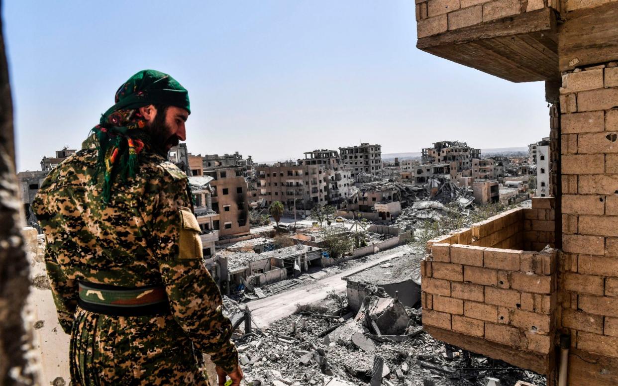 A member of the Syrian Democratic Forces (SDF), backed by US special forces, monitors the area on the western frontline in Raqqa on October 8, 2017 - AFP