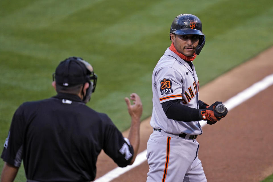 San Francisco Giants' Donovan Solano, right, looks at home plate umpire Alfonso Marquez and walks back to the dugout after striking out swinging against Oakland Athletics starting pitcher Chris Bassitt in the first inning of a baseball game Friday, Sept. 18, 2020, in Oakland, Calif. (AP Photo/Eric Risberg)