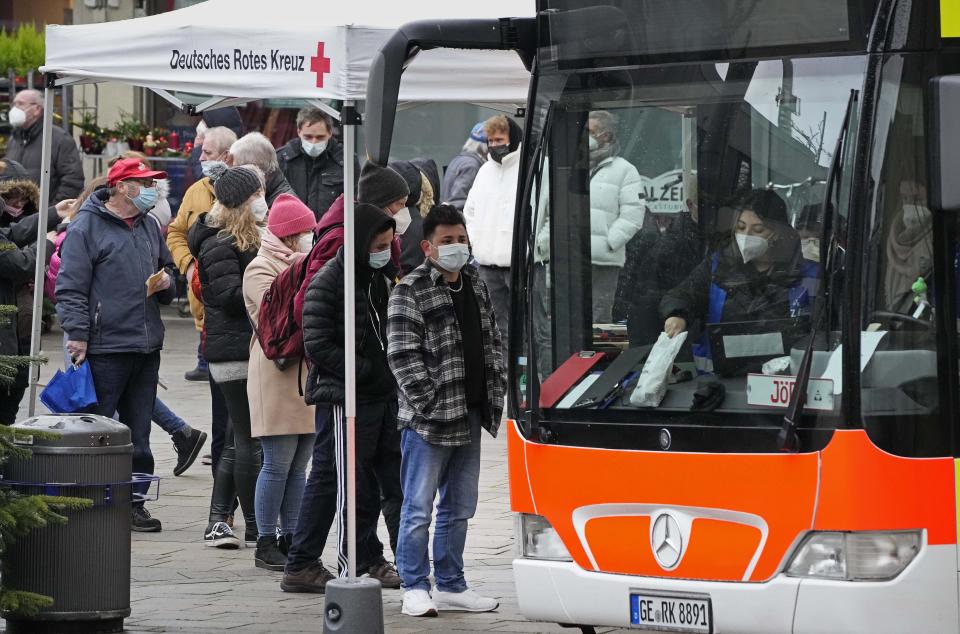 People line up for vaccination against the coronavirus and the COVID-19 disease at a mobile vaccination bus in Gelsenkirchen, Germany, Monday, Nov. 29, 2021. (AP Photo/Martin Meissner)