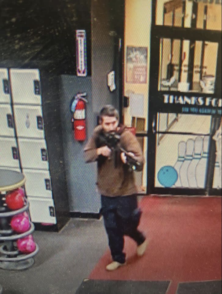 In this image taken from video released by the Androscoggin County Sheriff's Office, an unidentified shooter points a gun while entering Sparetime Recreation in Lewiston, Maine, on Wednesday, Oct. 25, 2023. Maine State Police ordered residents in the state's second-largest city to shelter in place Wednesday night as the suspect remains at large. (Androscoggin County Sheriff's Office via AP)