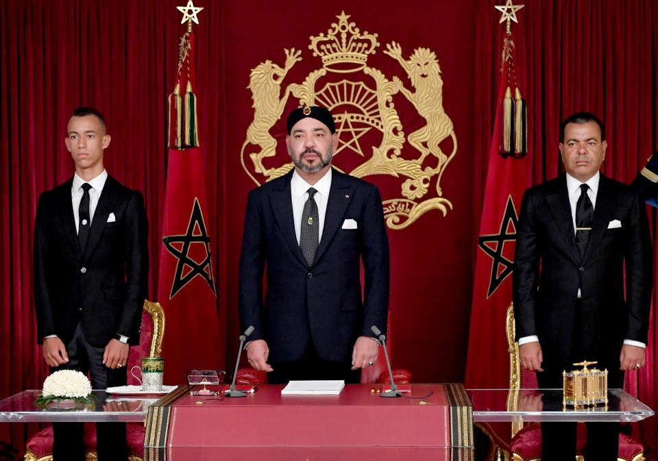 In this photo dated Sunday, July 29, 2018, released by the state news agency, Moroccan News Agency (MAP), and provided by the Moroccan Royal Palace, King Mohammed VI, is flanked by his brother Prince Moulay Rachid, right, and Crown Prince Moulay Hassan, during the annual Throne Speech, in Al-Hoceima, Morocco. Mohammed VI has criticized the North African kingdom's social development programs as overlapping, uncoordinated and missing target populations in a speech from the northern town that has been the epicenter for social unrest. (Moroccan Royal Palace via AP)