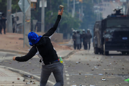 A supporter of Salvador Nasralla, presidential candidate for the Opposition Alliance Against the Dictatorship, throws a rock toward police during a protest while awaiting official presidential election results in Tegucigalpa, Honduras November 30, 2017. REUTERS/Jorge Cabrera