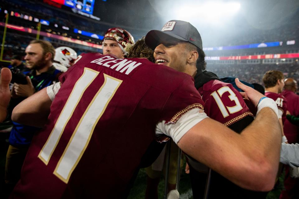 Florida State Seminoles quarterback Jordan Travis (13) hugs Florida State Seminoles quarterback Brock Glenn (11) as the team celebrates defeating the Louisville Cardinals 16-6 to claim the ACC Championship title in Charlotte, North Carolina on Saturday, Dec. 2, 2023.