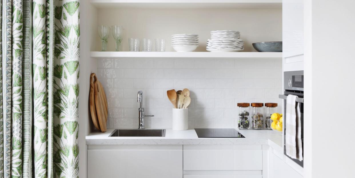 a small white kitchen behind a curtain