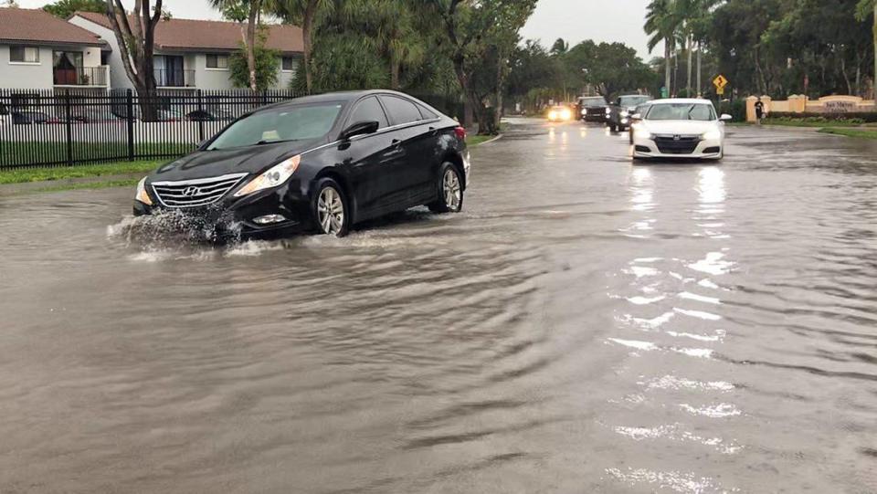 A car hits a submerged pothole while driving through flooded streets in Hialeah on November 10, 2020.